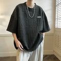 Men's grey t-shirt with a raised 3D letter print on the chest, showing a retro loose fit.