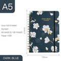 A5 spiral notebook with floral cover design, open to show lined pages.