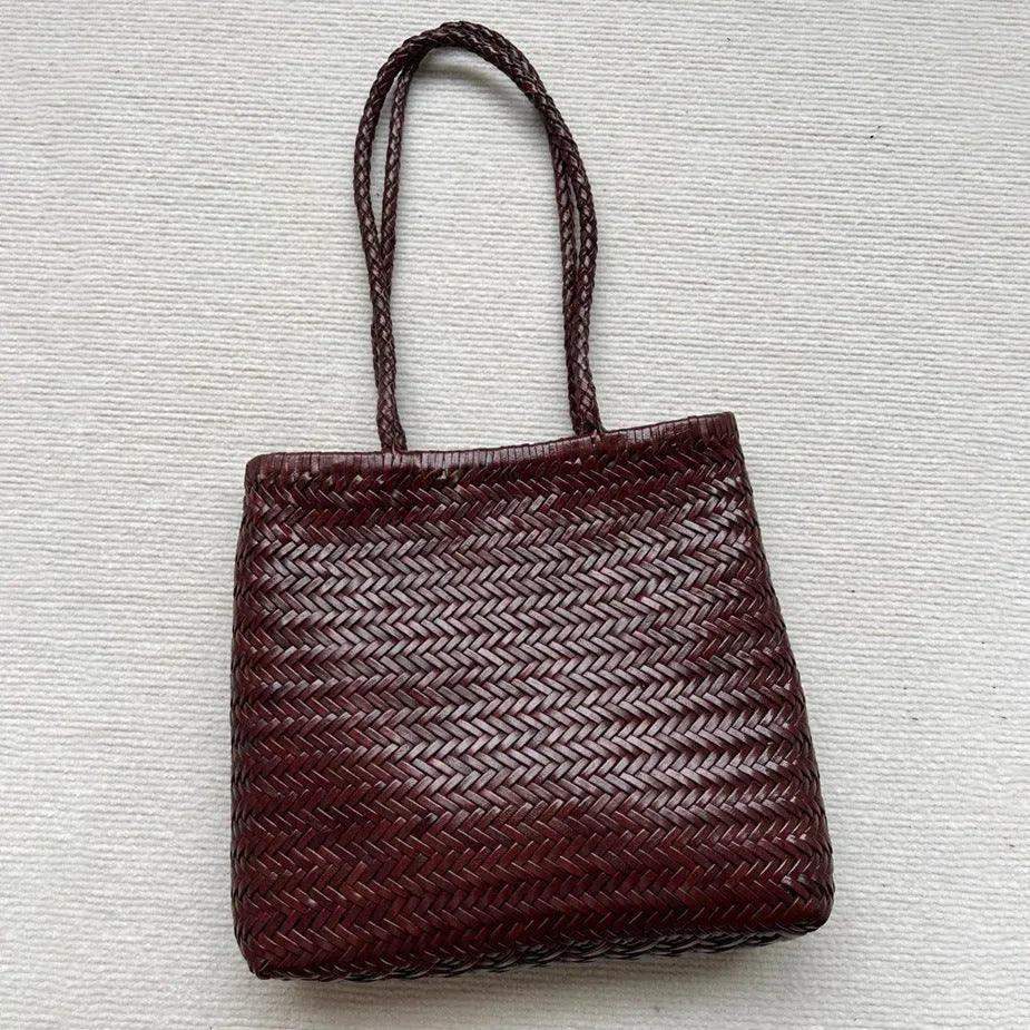 Brown handmade cowhide leather woven tote bag with a three-dimensional front pocket.