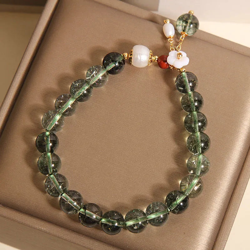 Green phantom quartz crystal bracelet for women with small shell flower and Bells of Ireland design details.