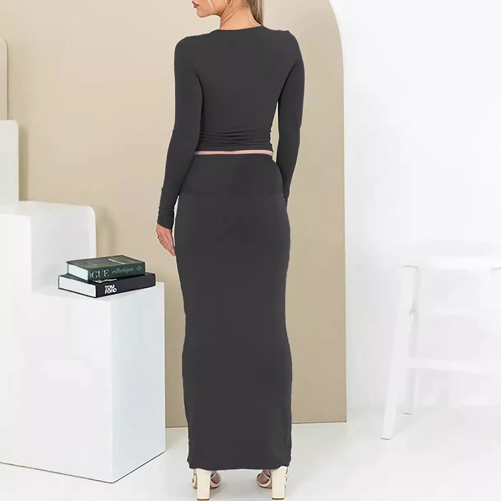 Women's black slim fit two-piece suit with exposed navel top and long skirt.