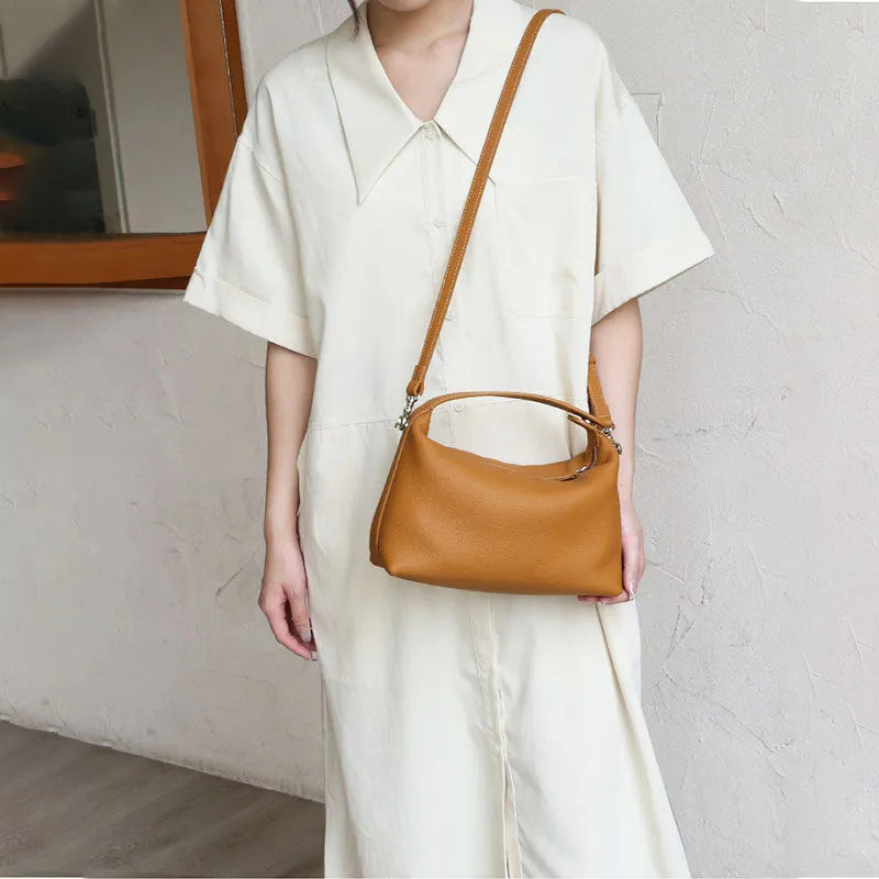 Genuine leather brown one shoulder lunch box bag with zipper closure and multiple internal pockets on white background