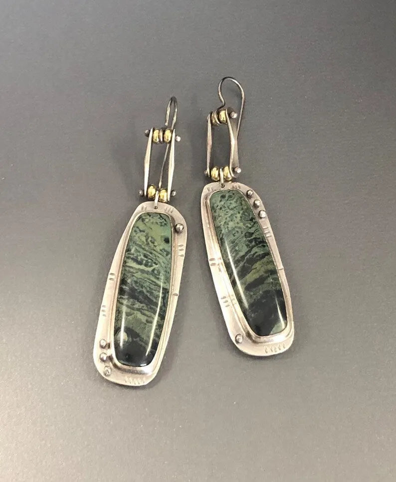 A pair of geometric drop earrings with a white and grey marble pattern on an alloy background.