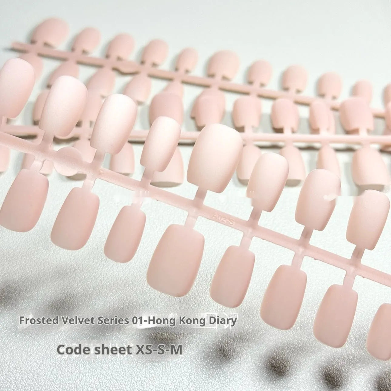 Set of frosted velvet cat's eye false nails with aurora armour design in short ladder sizes on a clear background.
