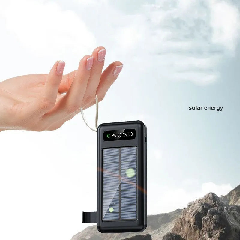 Black and white solar power bank showing size, solar panel, and USB ports for charging phones outdoors.