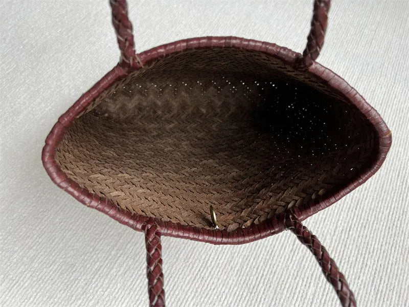 Brown handmade cowhide leather woven tote bag with a three-dimensional front pocket.