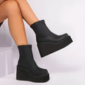 Women's black wedge-heel ankle boot with a round toe and waterproof platform sole on a plain background.