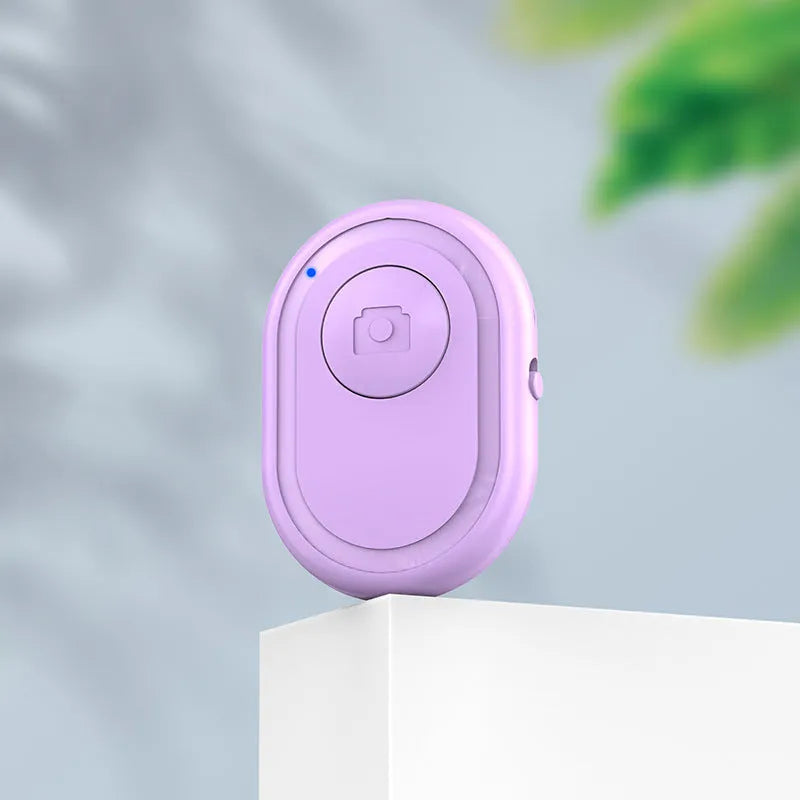 Wireless Bluetooth remote control for smartphone photography in black, pink, or purple colours