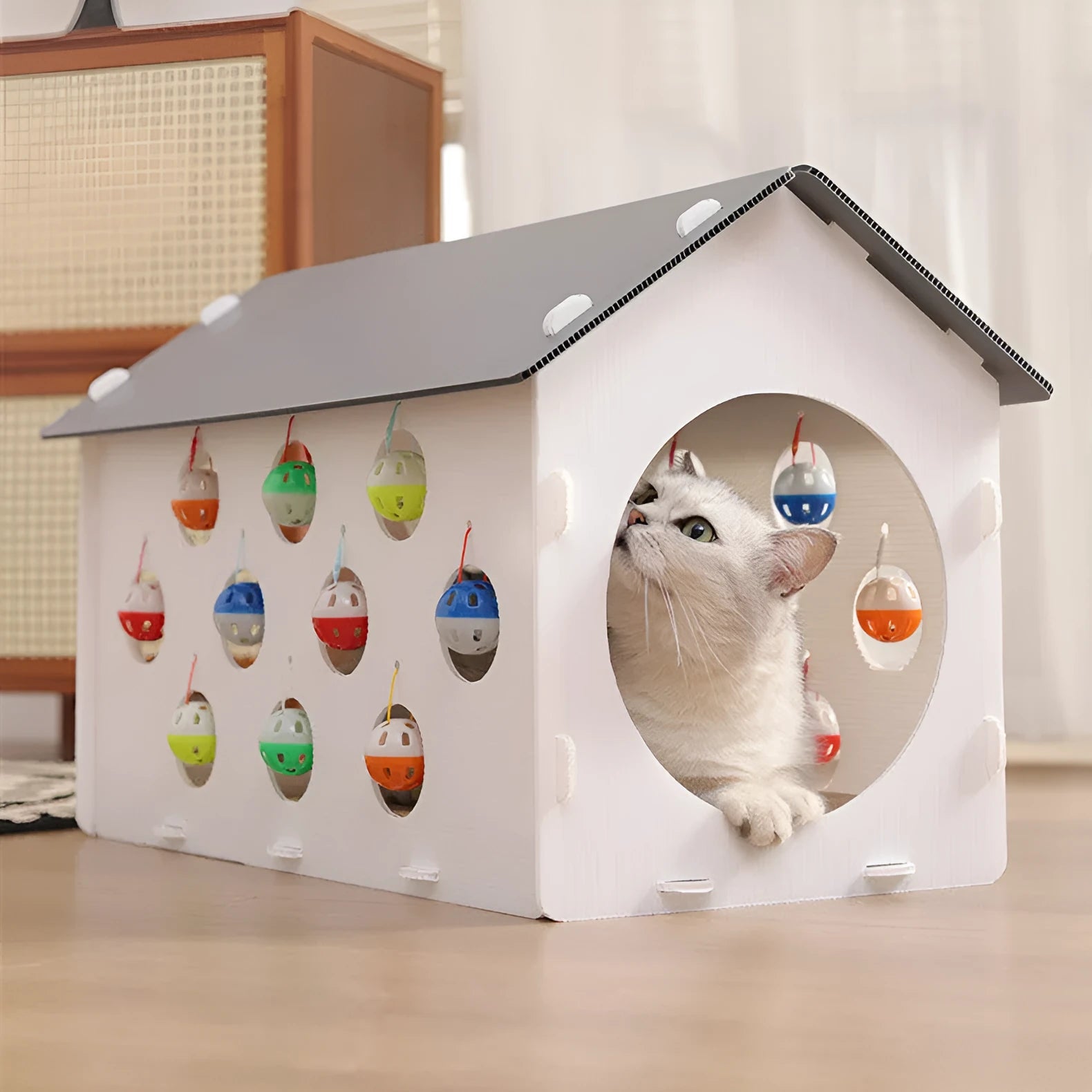 White plastic cat scratch board with integrated round nest bed and short tunnel with dangling bell ball