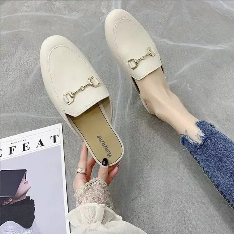Women's PVC closed toe half slipper in white with a double buckle, shown on a foot.