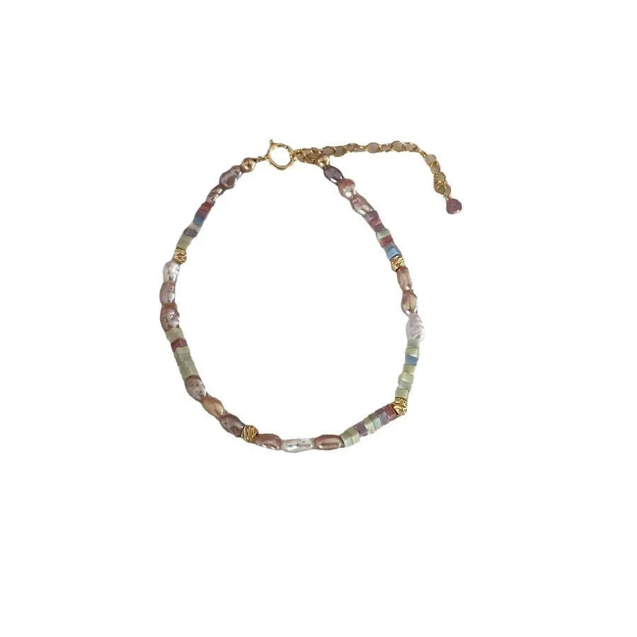 Women's natural pearl bracelet and necklace set with a purple and gold-plated clasp on a silver chain.