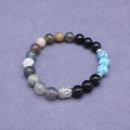 Natural stone elastic bracelet in a mixed colour pattern on a wrist.