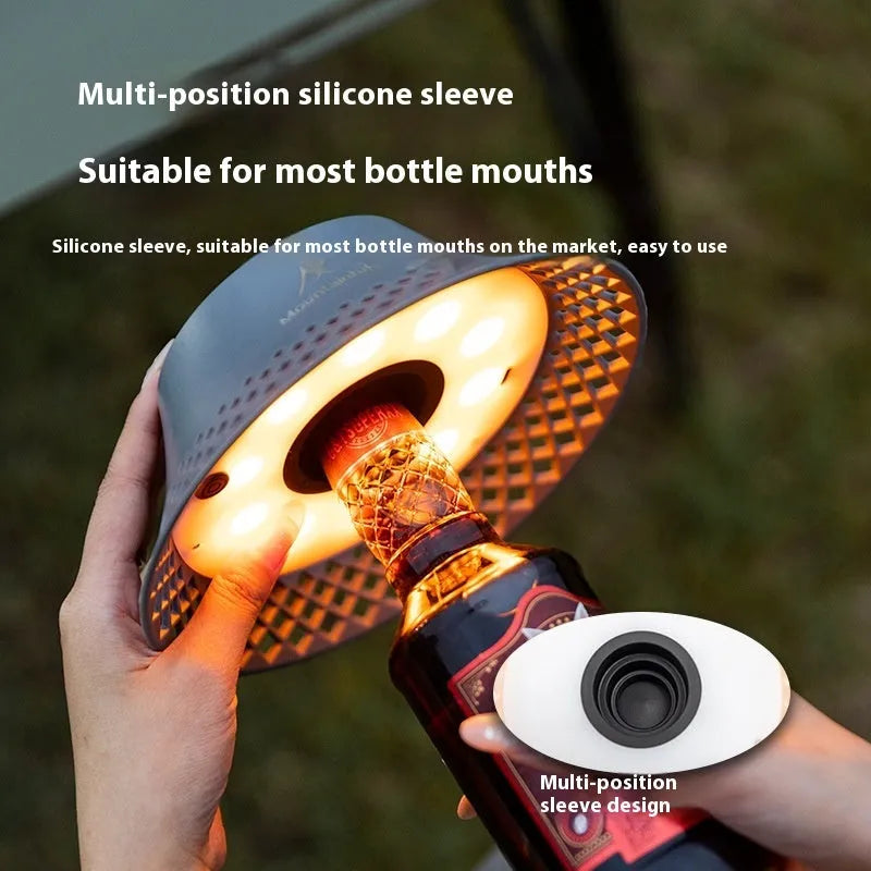 Beige fabric shade camping lantern on wooden table, powered by a repurposed wine bottle base with USB-C port.