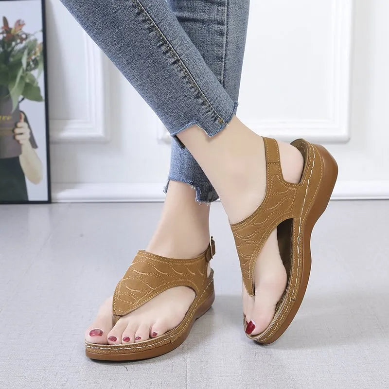 Women's wedge heel flip flop sandals with an adjustable back strap in solid black.
