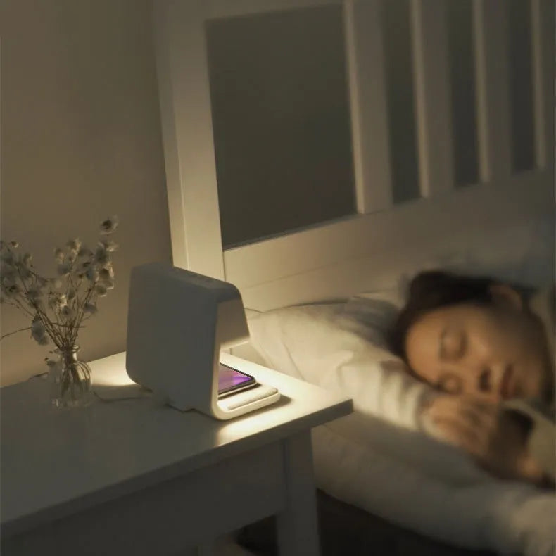 White bedside lamp with wireless charging pad and LCD clock display on base