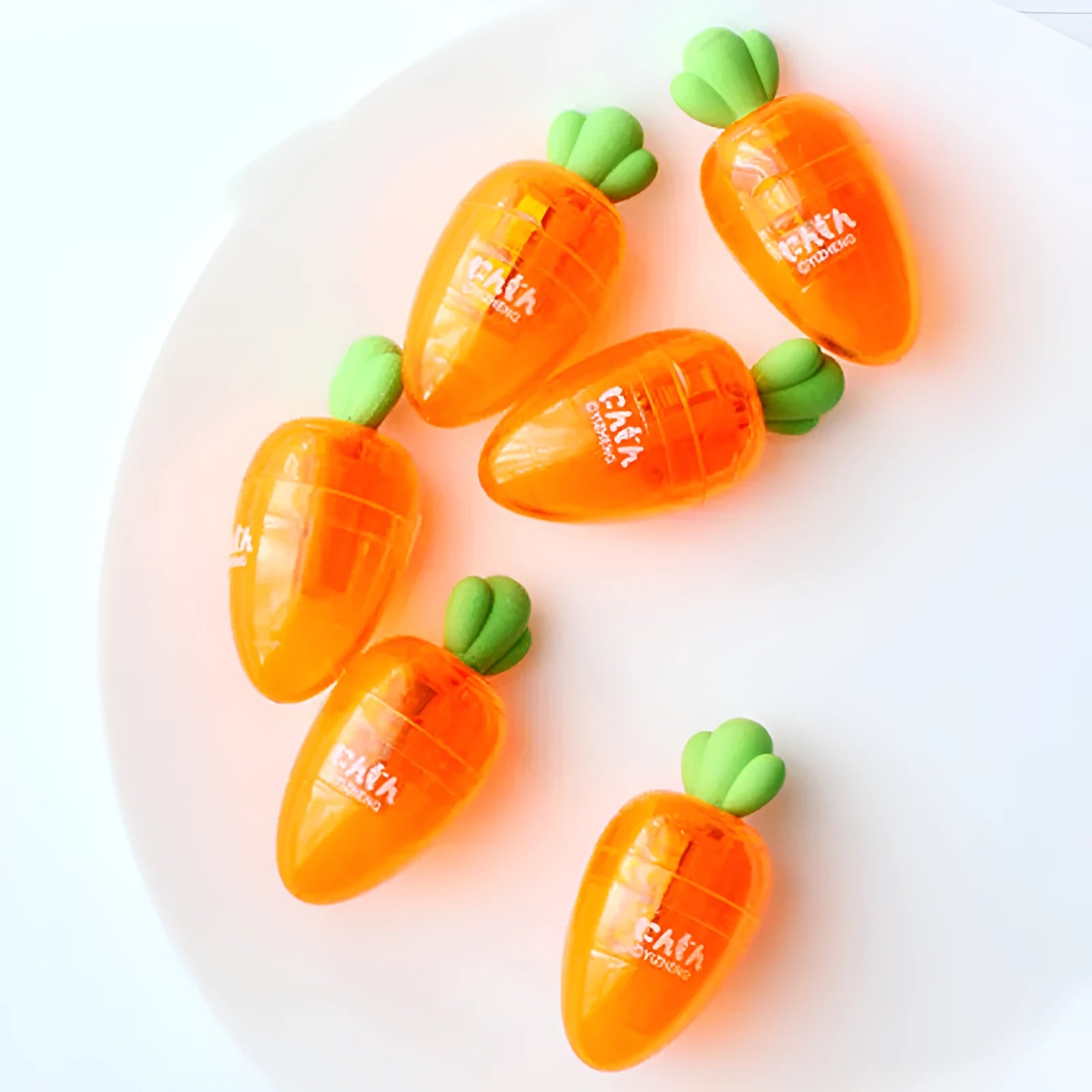 Carrot-shaped plastic pencil sharpener showing colourful design and 7cm length measurement