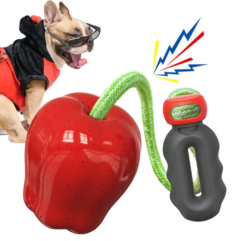Green plastic molar-shaped dog toy with a hollow centre for treats, on grass.