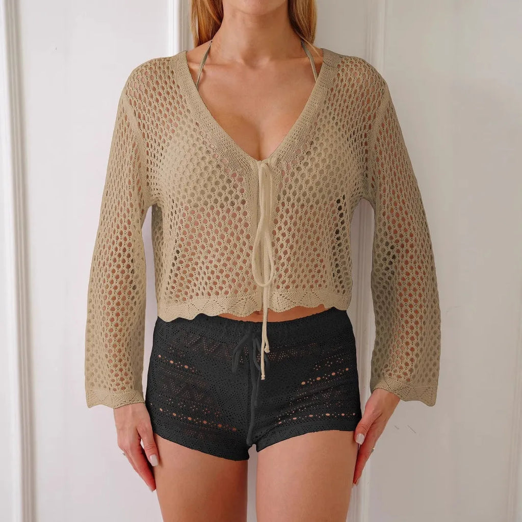Short apricot coloured women's cardigan blouse with flared bell sleeves, laid flat.
