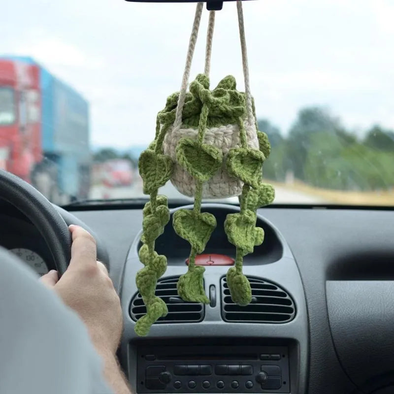 Green and white knitted wool car plant ornament hanging from a rope