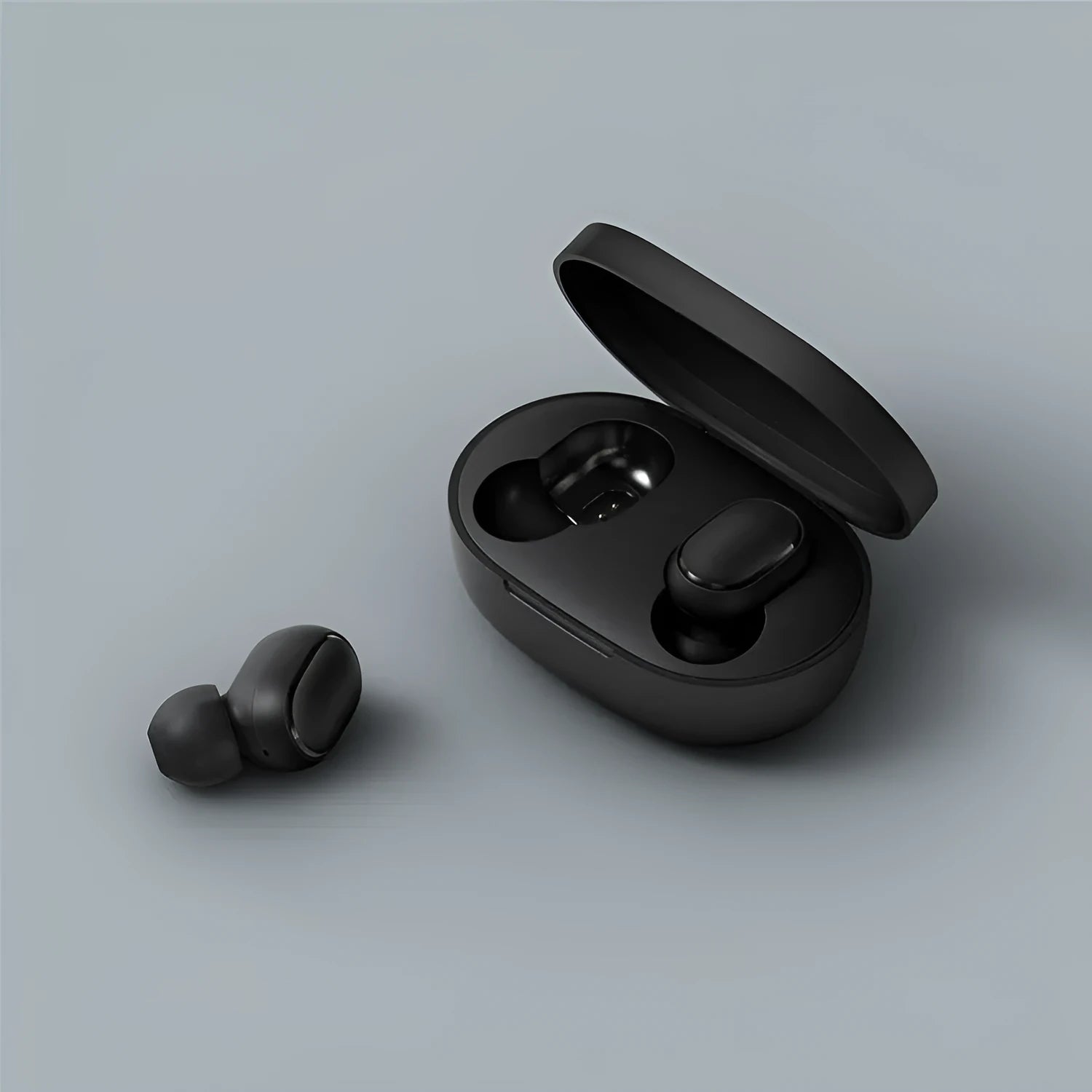 Black Redmi AirDots true wireless earbuds next to their compact charging case.