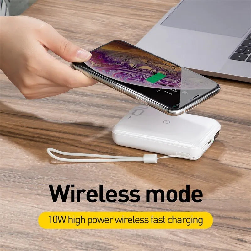 Small square black portable power bank with wireless charging surface and digital LED display.