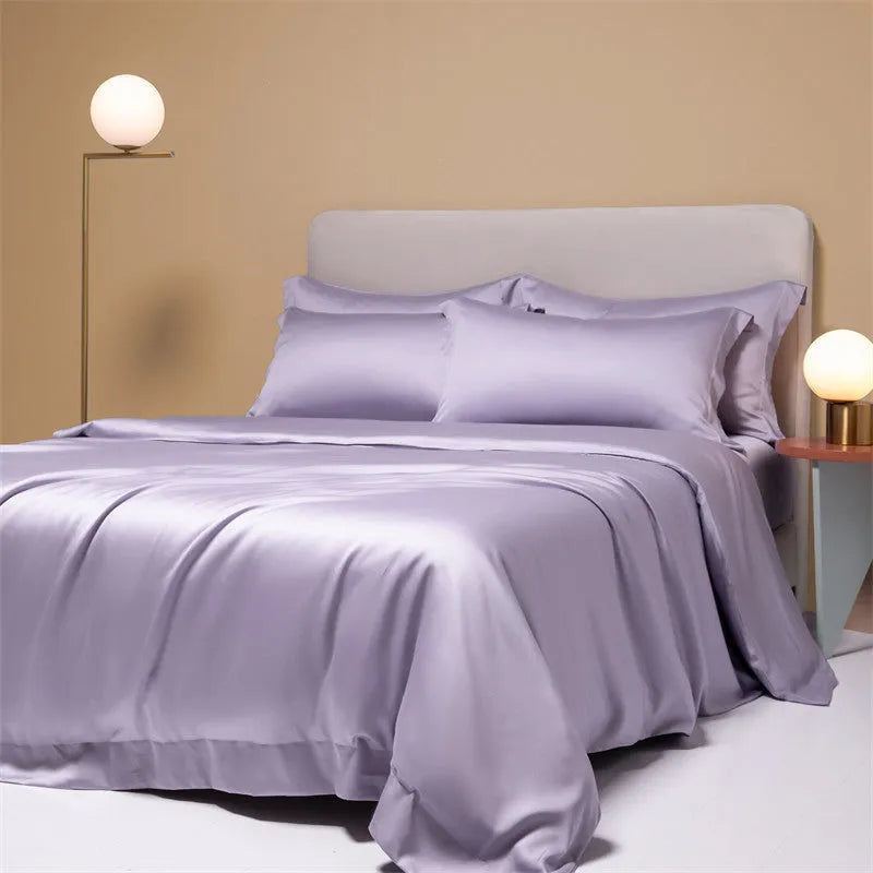 A neatly made bed with a Lenzing Tencel duvet cover and pillowcases in a soft grey colour.