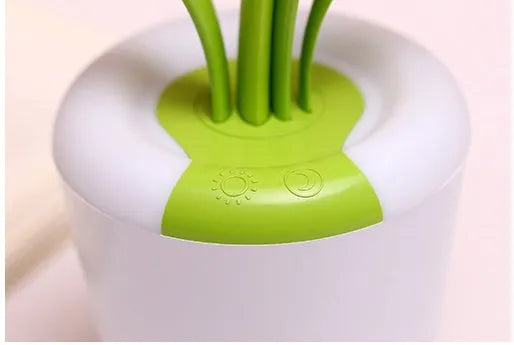 Modern rechargeable desk lamp with plant shape design in pink, showing touch control on a wooden end table