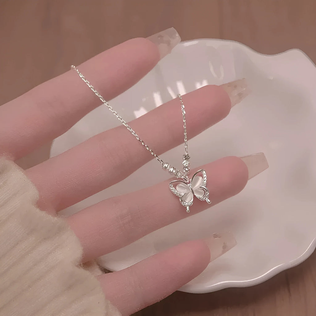 Women's silver opal butterfly necklace on a cross chain, showing adjustable length between 41 and 50 cm.