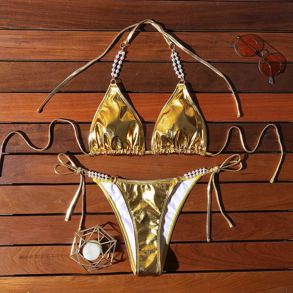 Gold halter neck bikini with lace-up front and pearl chain decoration