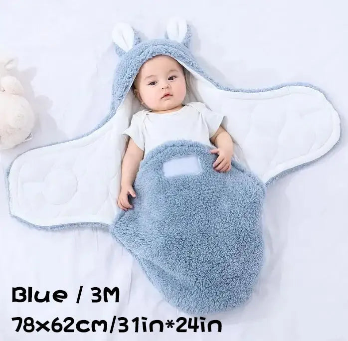 Baby wearing a grey adjustable fleece swaddle sleep sack with velcro wings
