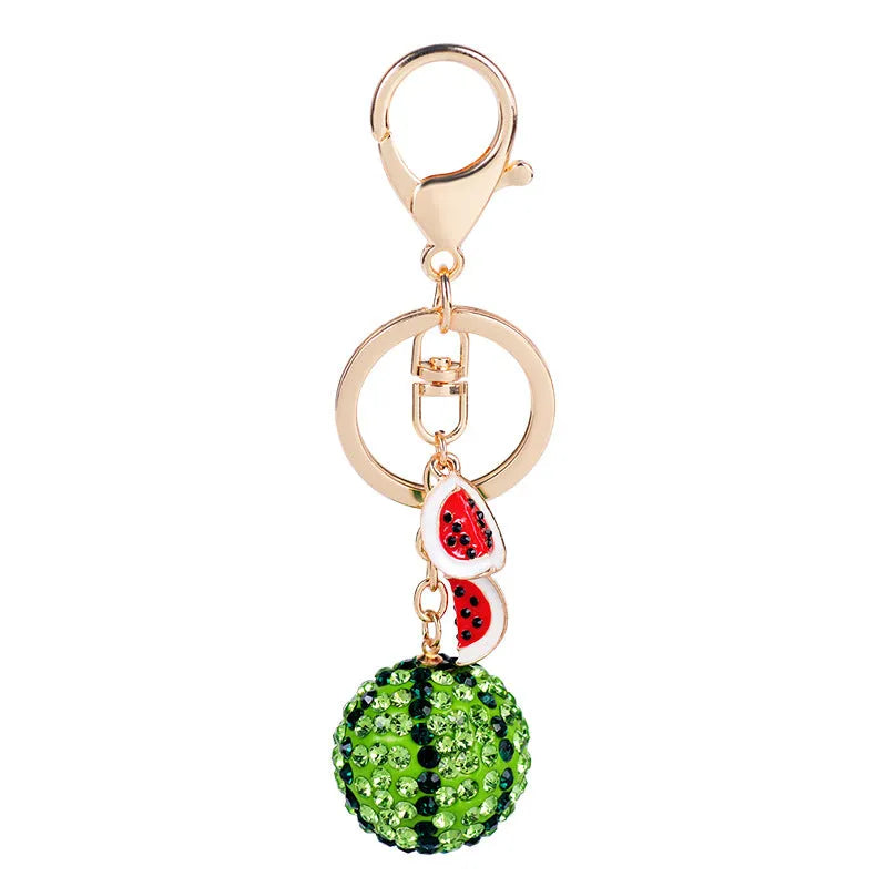 Green watermelon-shaped metal keychain on a white background