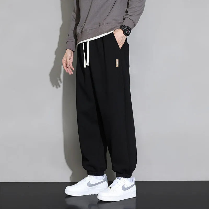 Men's loose grey cotton sports trousers with elastic waistband on hanger
