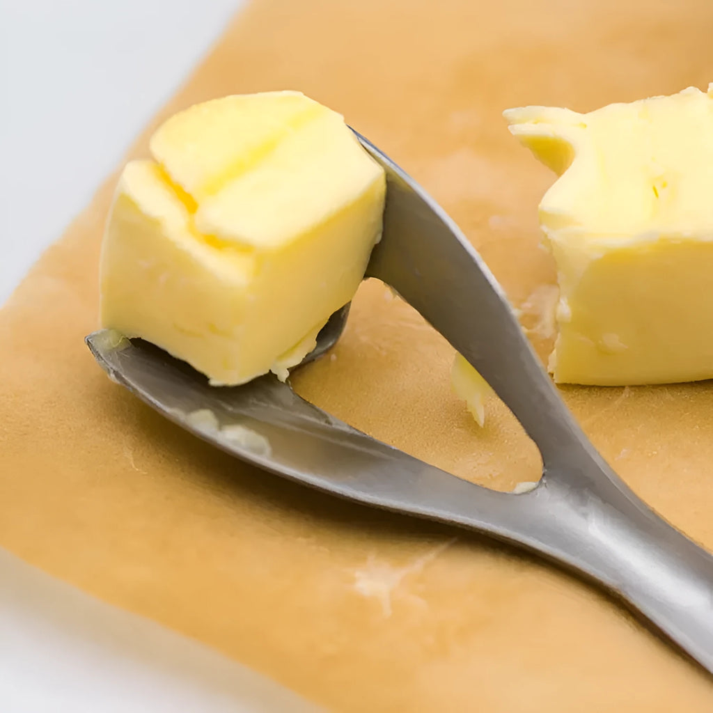 Stainless steel butter cutter with 12cm blade and sharp edge on a surface