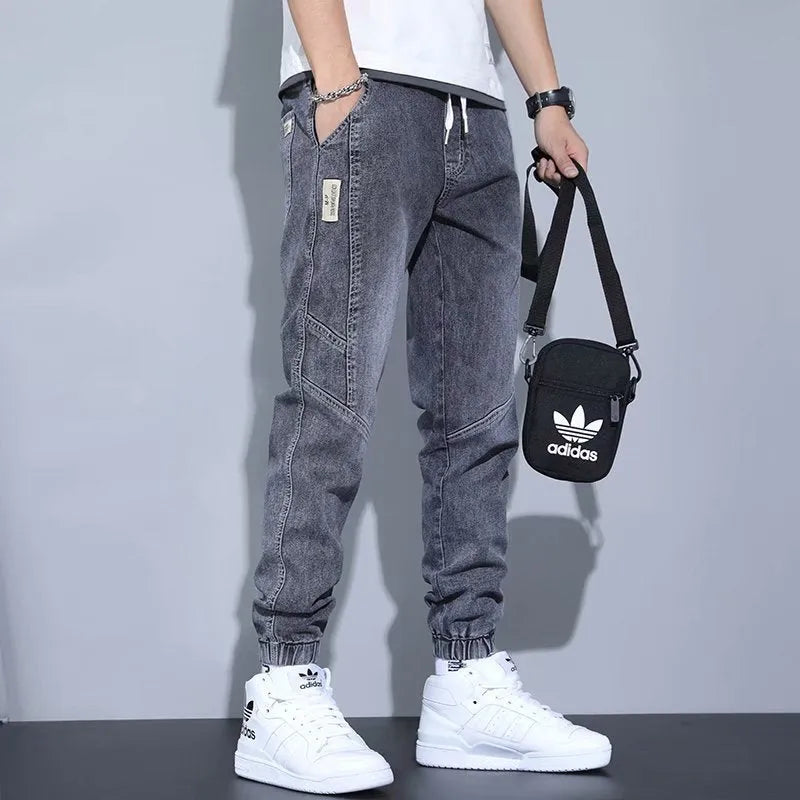 Men's slim fit straight-leg jeans in blue denim with high waist and ankle-tied style