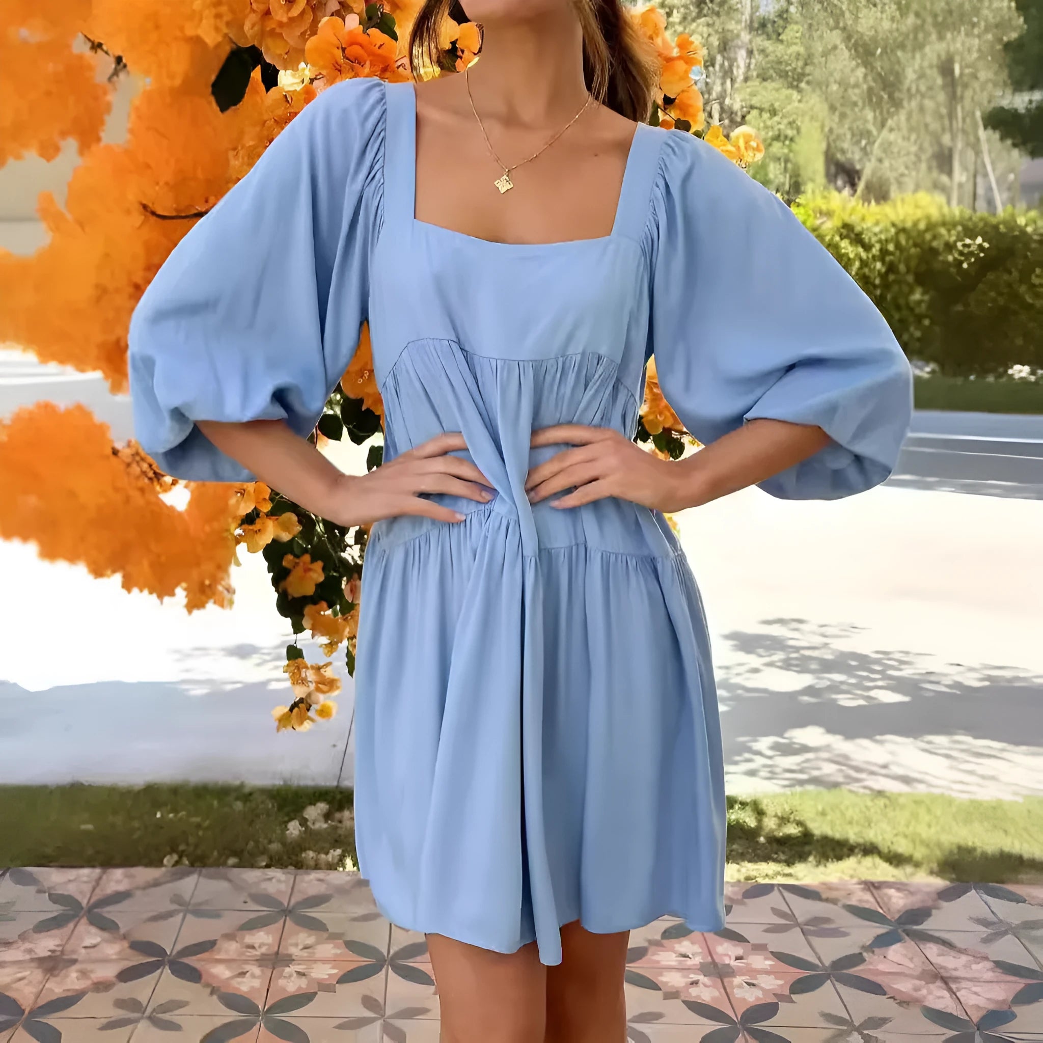 Light blue children's backless dress with square collar and puff sleeves on a mannequin.