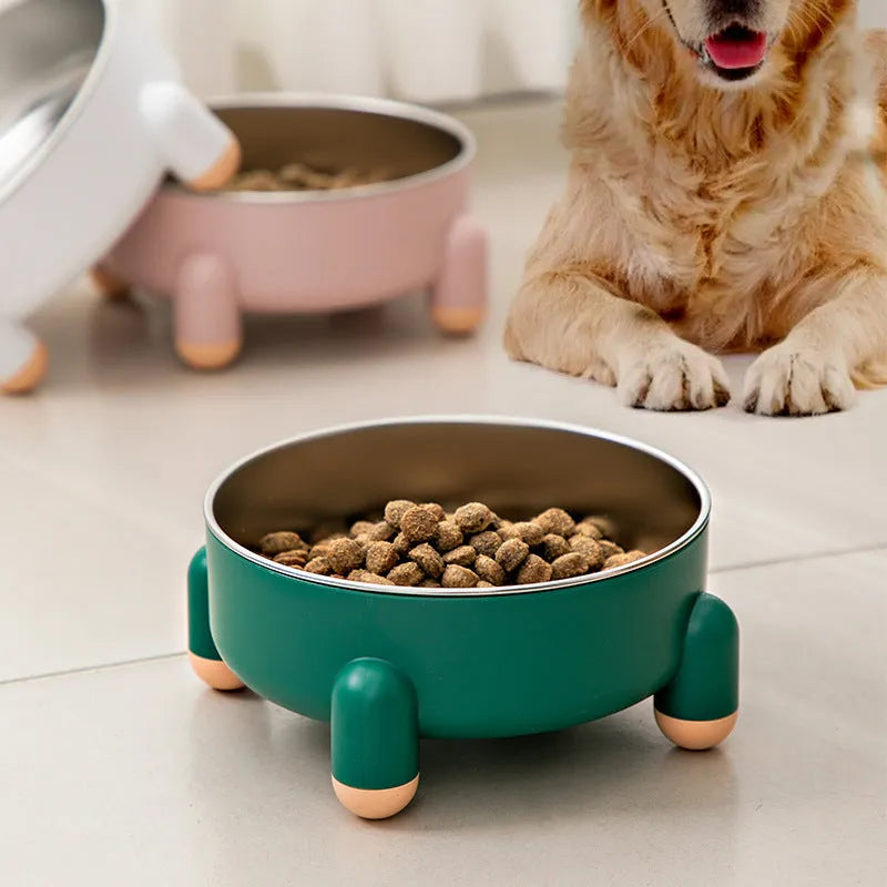 Green stainless steel pet bowl with non-slip base and raised high foot on a wooden floor.