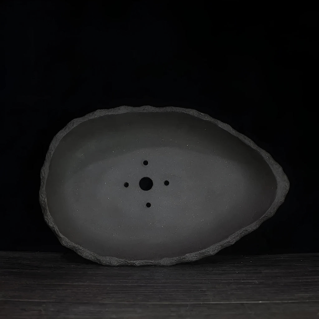 Handmade purple clay flower pot showing unique shape and natural ceramic texture