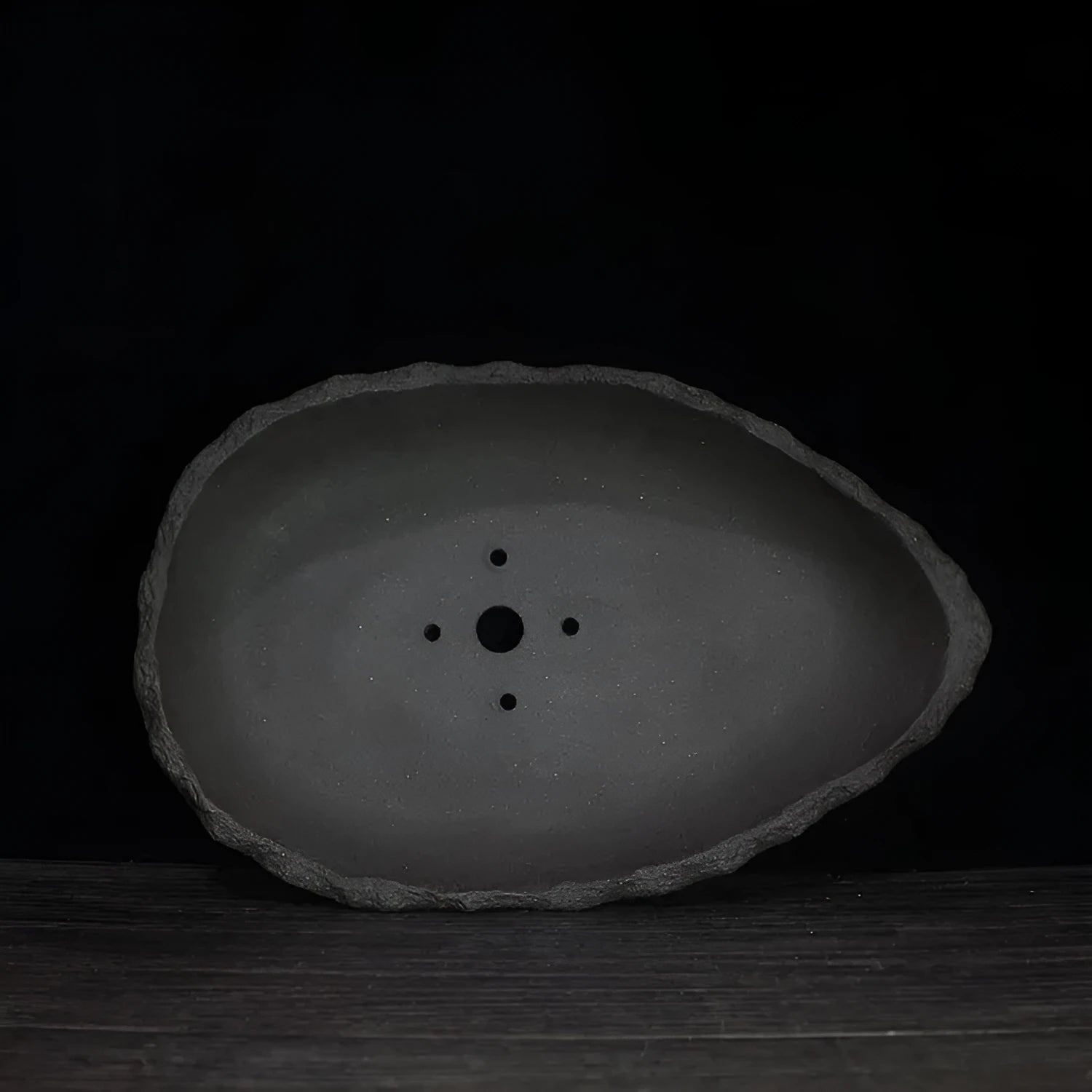 Handmade purple clay flower pot showing unique shape and natural ceramic texture