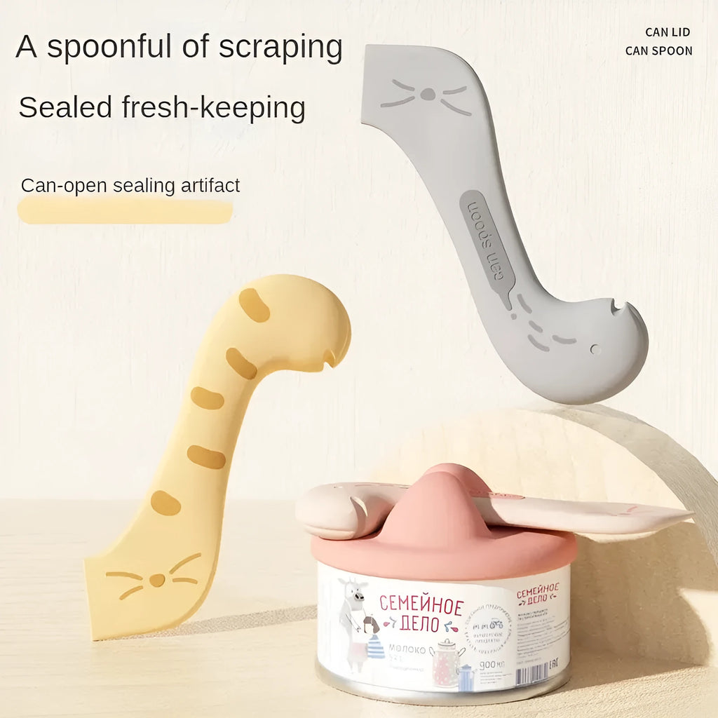 Grey silicone pet food spoon with integrated can opener and matching sealing lid for tins.