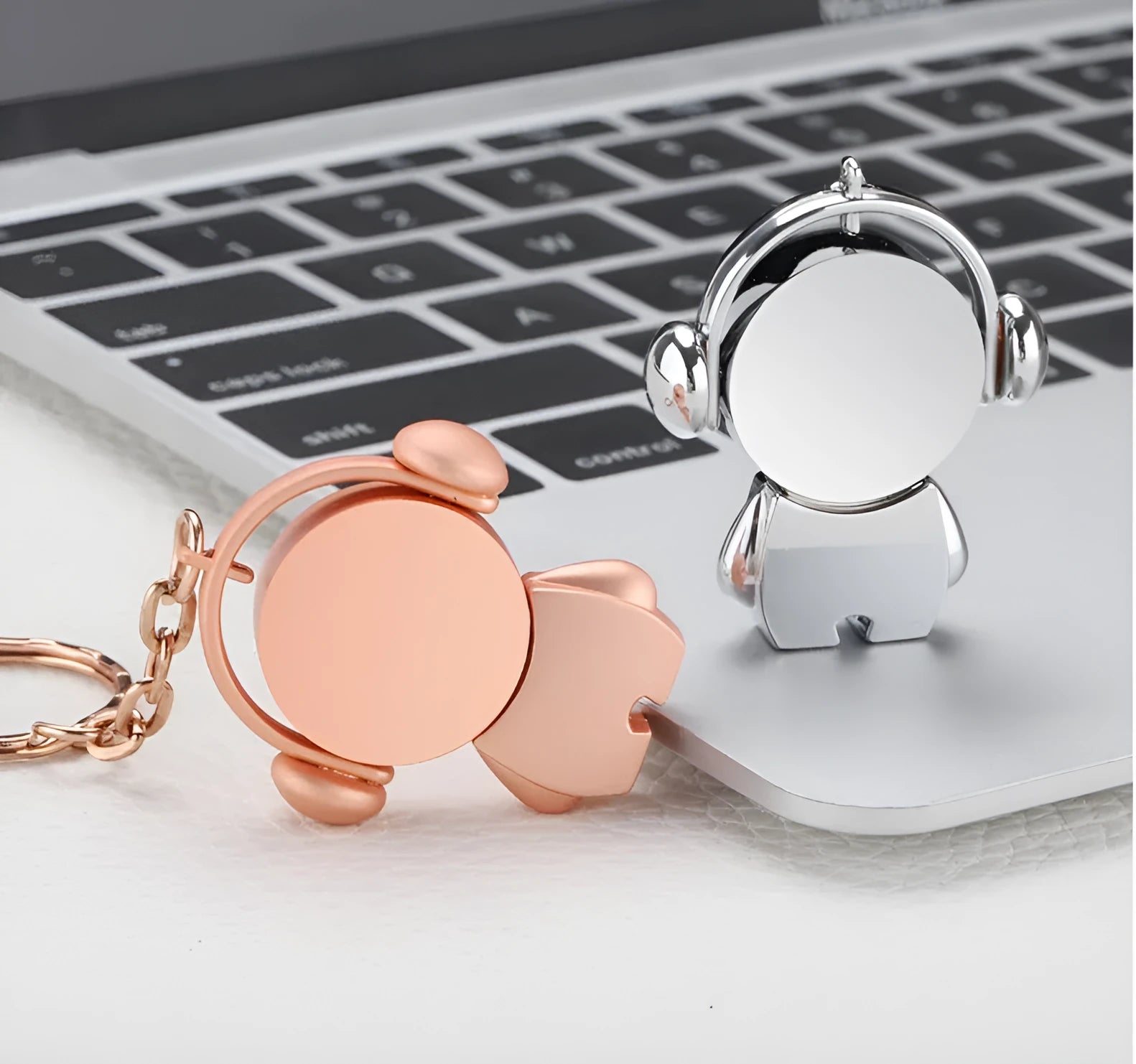 Silver and rose gold metal USB flash drives with musician cartoon designs showing compact dimensions