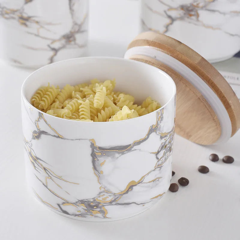 3 piece marbled ceramic jar set with wooden lids large medium and small on a countertop