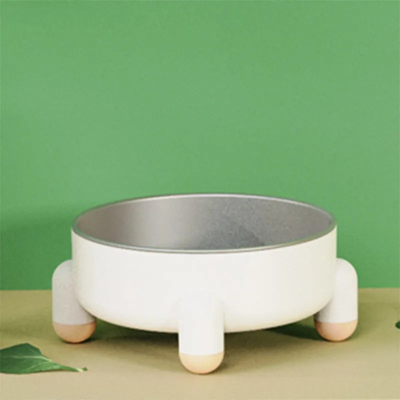 Green stainless steel pet bowl with non-slip base and raised high foot on a wooden floor.