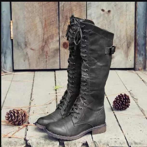 Black chunky heel high leg boots on a white background, showing round toe and stout low heel.