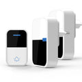 White self-powered wireless doorbell transmitter and plug-in receiver on a wooden table.