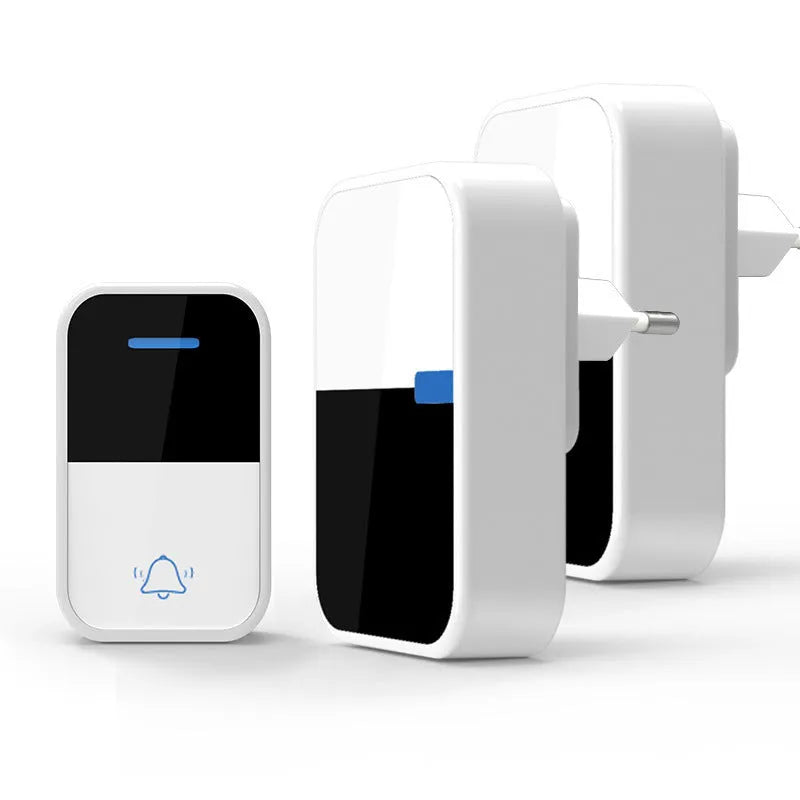 White self-powered wireless doorbell transmitter and plug-in receiver on a wooden table.