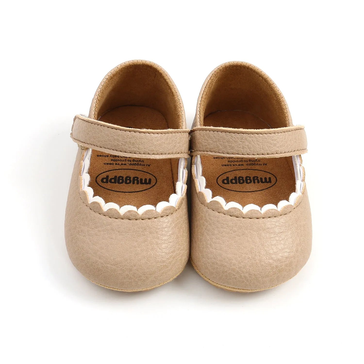 White low-cut velcro toddler shoes for baby girls and boys on a plain background.