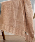 Beige and brown cotton towel set showing bath towel, hand towel, and face cloth sizes