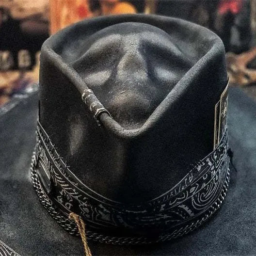 Handmade wool felt conical crown skull hat for Halloween costumes on a dark background.