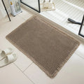 A beige checkered non-slip polyester bathroom carpet on a tiled floor.