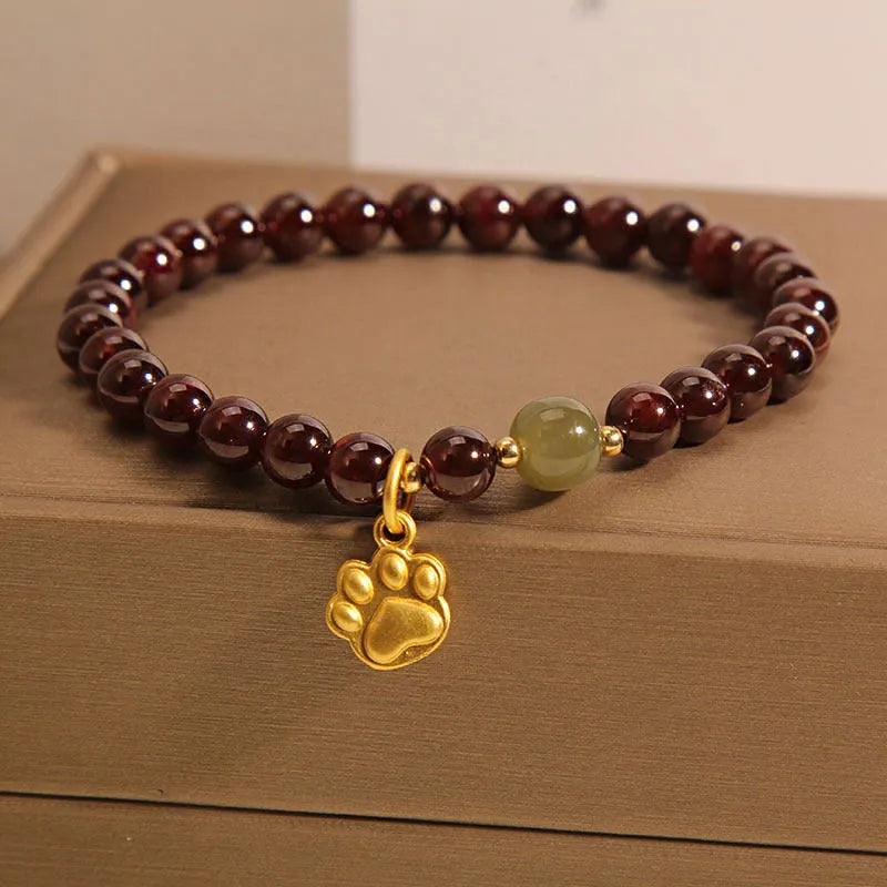 Women's Cat's Paw Garnet crystal bracelet on wrist, original design.